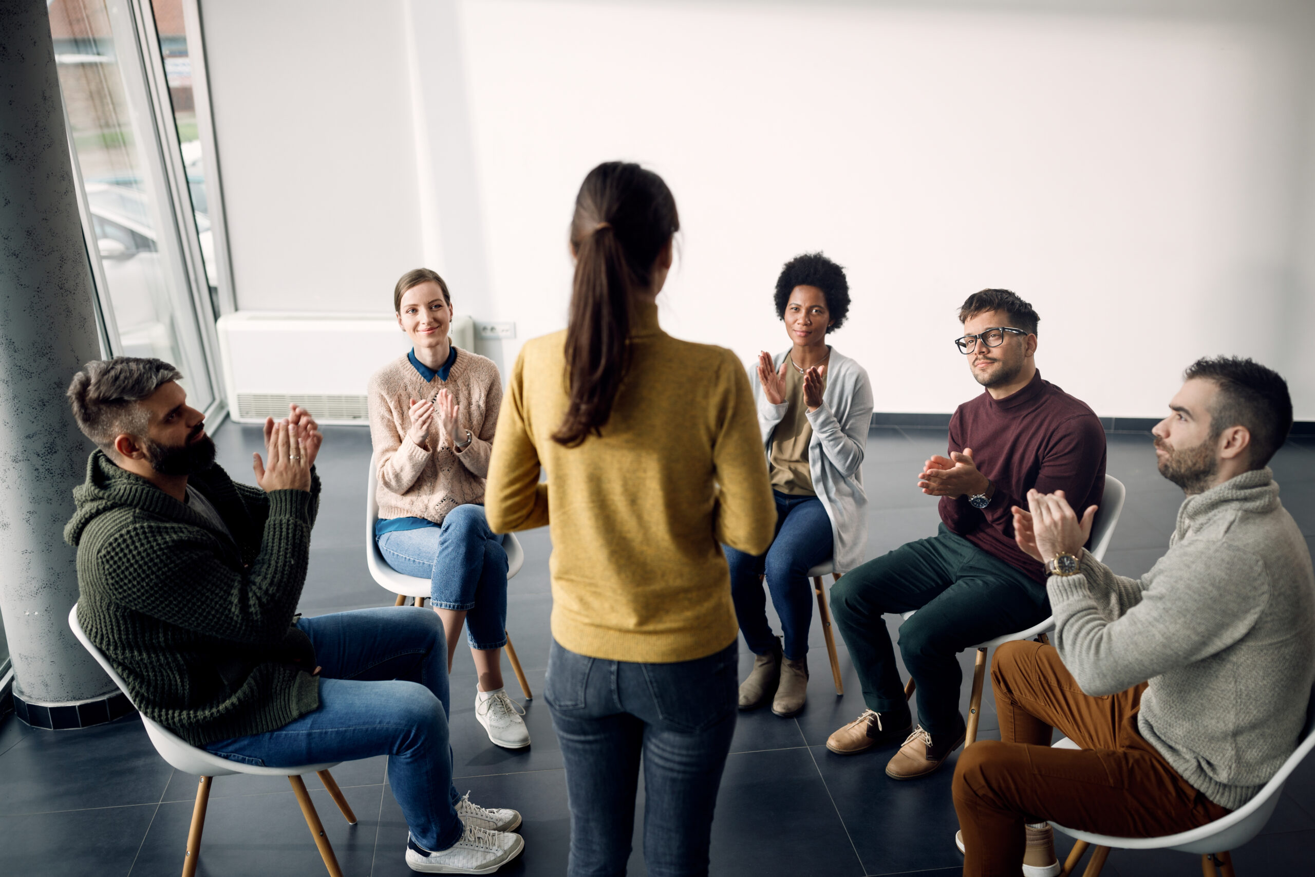 group therapy attenders applauding to one of the participant dur